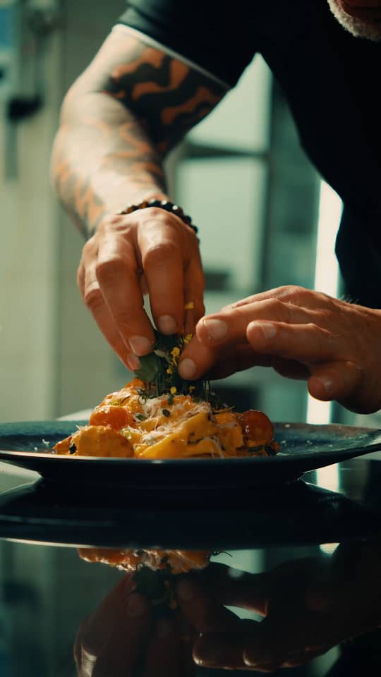 Plating a finished dish with fresh herbs